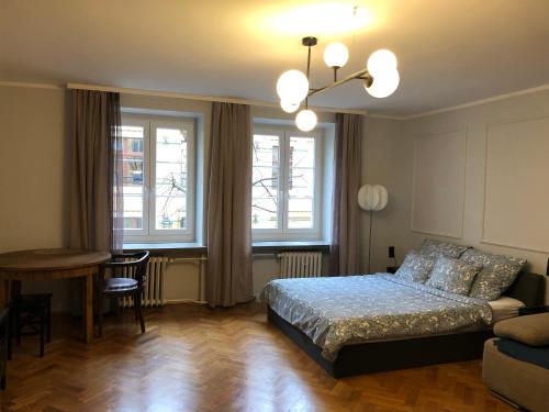 sypialnia z łóżkiem, stołem i oknami w obiekcie Apartament Central Nº1 we Wrocławiu