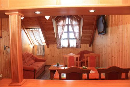 a living room with a couch and a table at Radics Panzió Étterem és Pihenő Központ in Letenye