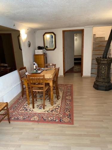 une salle à manger avec une table et des chaises sur un tapis dans l'établissement La Maisonnette D'Agel, à Agel