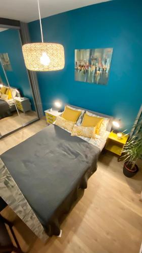 sypialnia z łóżkiem z niebieską ścianą w obiekcie Apartament Urodzajna w Bielsku Białej
