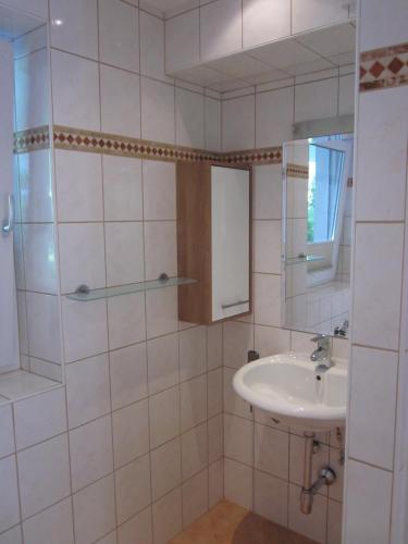 a white bathroom with a sink and a mirror at Ferienwohnung Bergpanorama in Fulpmes