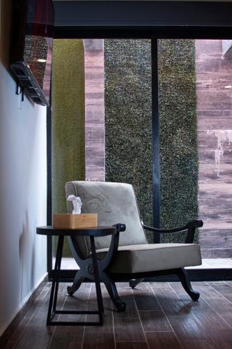 a chair and a table in front of a window at Casa Bruna Luxury Lofts in Tampico