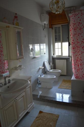a bathroom with two sinks and a toilet and a tub at B&B Le Rose in Vignacastrisi