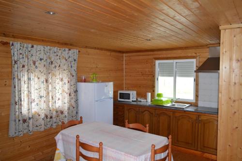 a kitchen with a table and a white refrigerator at Quinta da Fonte de Grandola in Grândola