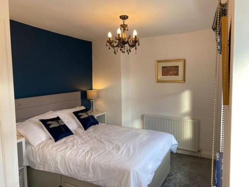 a bedroom with a bed with a mirror and a chandelier at Custard creams cottage in Knaresborough