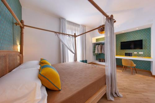 1 dormitorio con cama con dosel y TV en Gorgeous apartment in the center: SORRENTO!, en Sorrento