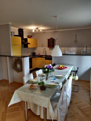 a kitchen with a table with plates and flowers on it at The Lovely Garden House in Zagreb