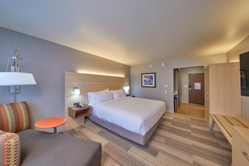 a hotel room with a bed and a couch at Holiday Inn Express & Suites - Hermiston Downtown by IHG in Hermiston