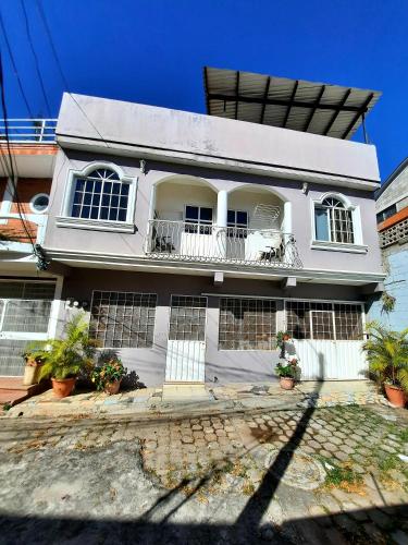 a white house with windows and a balcony at Cómodo Apartamento privado in Tegucigalpa