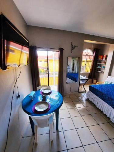 a room with a blue table and a bed at Cómodo Apartamento privado in Tegucigalpa