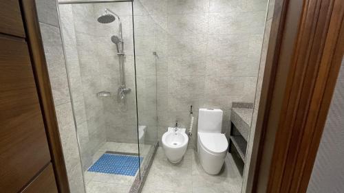 a bathroom with a toilet and a glass shower at CHlNOR HOTEL in Andijan