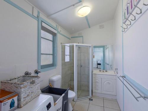 a bathroom with a shower and a toilet and a sink at Pacific Family Retreat in Long Jetty