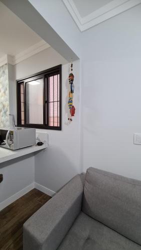 a living room with a couch and a window at Lazer Aconchegante na Guilhermina in Praia Grande