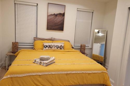 a bedroom with a yellow bed with towels on it at Brand new home in South Philly!!! in Philadelphia