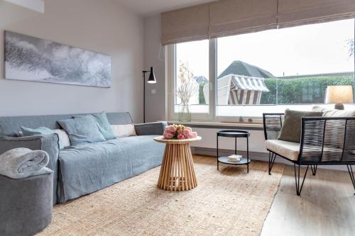 - un salon avec un canapé bleu et une table dans l'établissement Seetiid, à Westerland