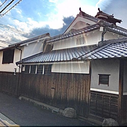 a house with a wooden fence in front of it at 古民家民泊かえるて in Kashihara