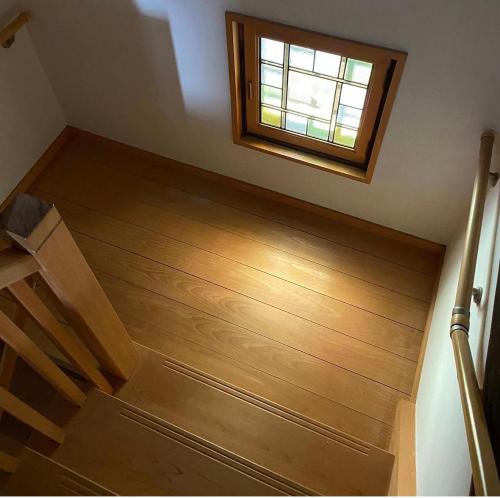an empty room with a wooden floor and a window at 古民家民泊かえるて in Kashihara