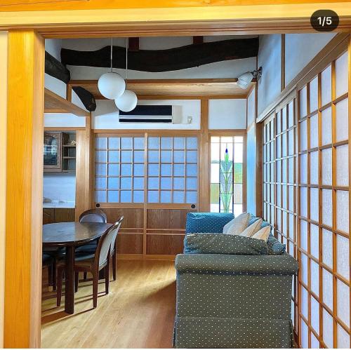 a living room with a table and a dining room at 古民家民泊かえるて in Kashihara