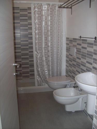 a bathroom with two toilets and a sink and a shower at Hotel Lisa in Pineto