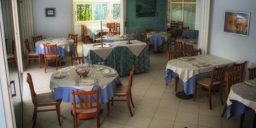 ein Restaurant mit Tischen und Stühlen sowie blauen und weißen Tischdecken in der Unterkunft Hotel Lisa in Pineto