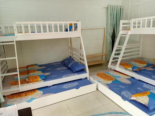 a room with two bunk beds with blue and orange sheets at Noel Homestay in Hiếu Xương