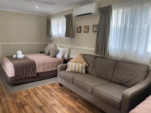 a living room with a couch and a bed at NRMA Atherton Tablelands Holiday Park in Atherton