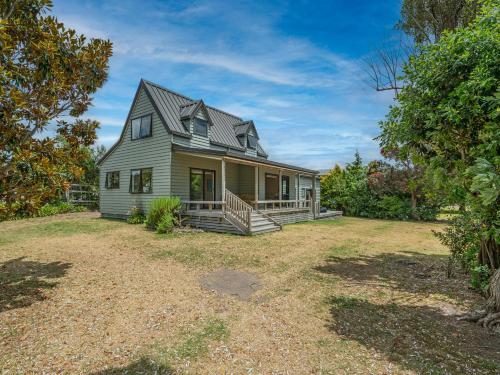 a house with a large yard in front of it at Seas the Day - Matarangi Holiday Home in Matarangi
