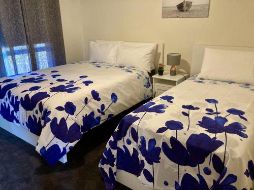 a bedroom with two beds with blue at CandE on Buller in Kingscote