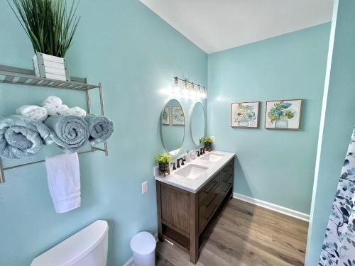 a blue bathroom with a sink and a mirror at Charming, Beautiful, Treetop Loft, Prime Location in Wilmington
