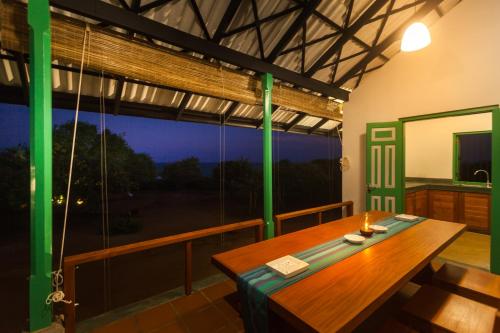 une salle à manger avec une table et une grande fenêtre dans l'établissement Nil Sisila Beach Resort Yala, à Yala