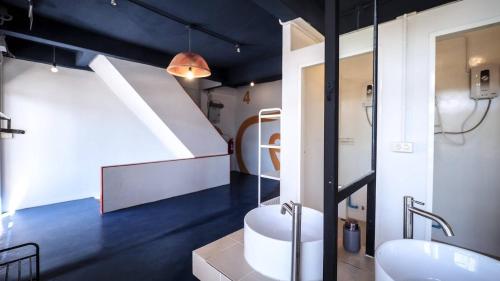 a bathroom with a tub and a sink and a staircase at Hoft Hostel Bangkok in Bangkok