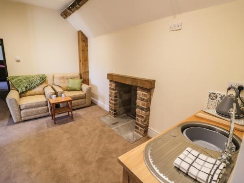 ein Wohnzimmer mit einem Sofa und einem Kamin in der Unterkunft Lea Farm House in Kidderminster