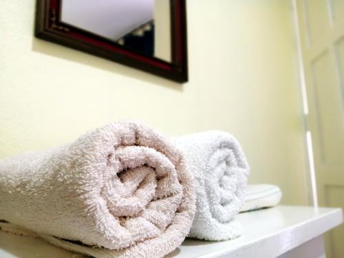 a pile of towels sitting on a counter in a bathroom at Hostal Mariella in Estelí