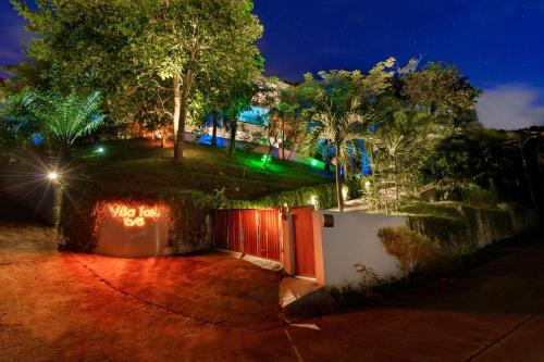 a house with a gate with lights on it at night at Villa Tosti in Ban Bang Po