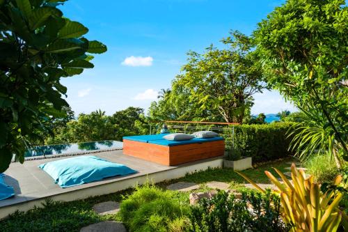 a bed in the middle of a garden at Villa Tosti in Ban Bang Po
