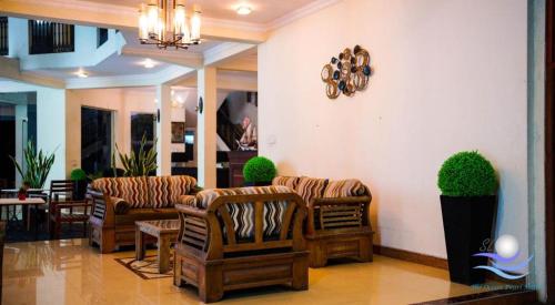 a lobby with couches and chairs and a clock on the wall at The Ocean Pearl Hotel Negombo in Negombo