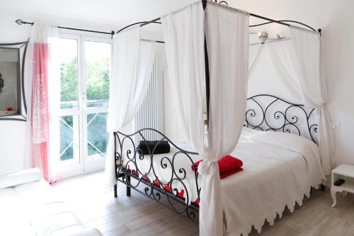 a bedroom with a black canopy bed with white curtains at B&B Rabbit in Cervia