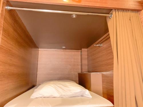 a bed in a room with a wooden wall at Omah Pelem Syariah in Semarang