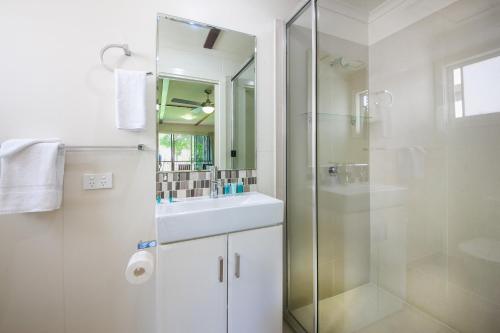 een witte badkamer met een wastafel en een douche bij NRMA Agnes Water Holiday Park in Agnes Water
