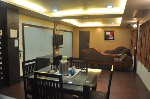 a living room with a table and a couch at Hotel Metro Palace Bandra in Mumbai