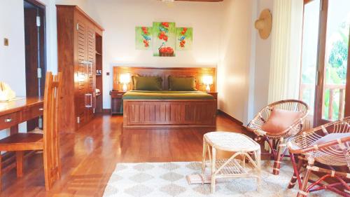 a bedroom with a bed and a desk and chairs at Lagoon gate Tangalle Resort in Tangalle
