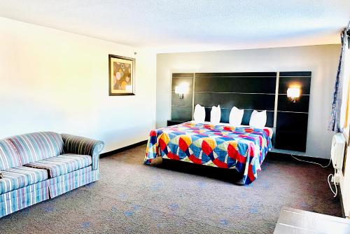 a hotel room with a bed and a couch at Coratel Inn & Suites by Jasper Northfield in Northfield