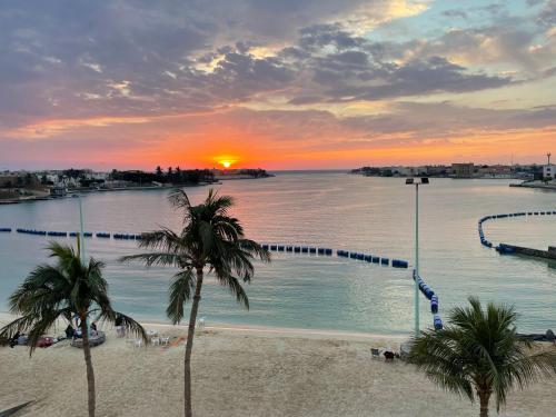 a view of a pool with palm trees and a sunset at sun sets for family only in Durat  Alarous