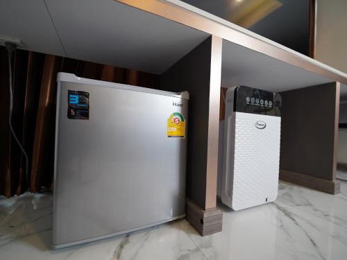 a white refrigerator next to a computer in a room at RoomQuest Sukhumvit36 BTS Thonglor in Bangkok