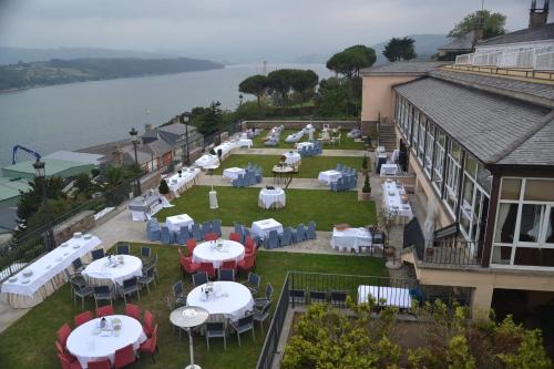 an outdoor restaurant with tables and chairs and the water at Parador de Ribadeo in Ribadeo