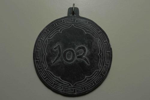 a black medal with the number on it at Shambaling Boutique Hotel in Kathmandu
