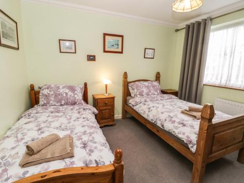 een slaapkamer met 2 bedden en een raam bij Park View in Filey