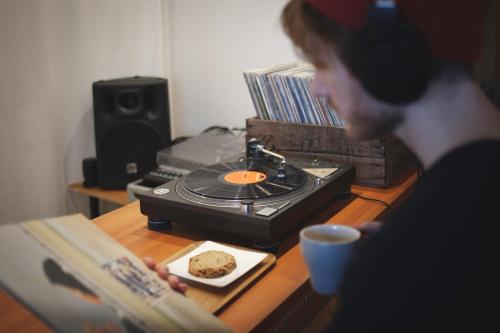a man is reading a book next to a table with a plate of food at FOLK FOLK Hostel, Cafe & Bar in Ise