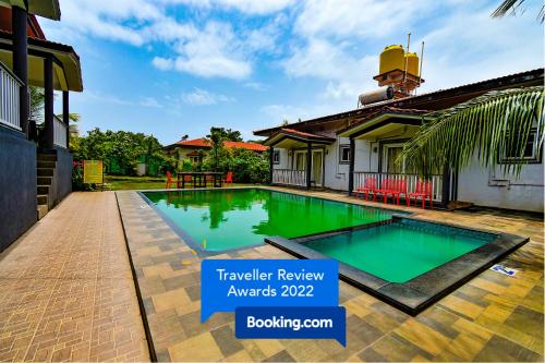 a swimming pool in front of a house at FabEscape Vagator Retreat Resort With Swimming Pool in Goa Velha