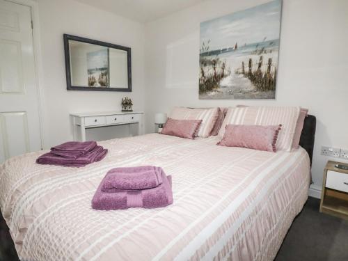 um quarto com uma cama grande e toalhas roxas em Sailors Retreat em Camelford